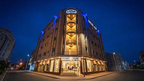 Un hotel con un atrio central, varios pisos y una entrada destacada.