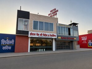 A hotel with a sign reading 'Hotel Dev Shree Palace' and 'Royal Enfield' on the facade. - Hotel Dev Shree Palace (Ujjain)