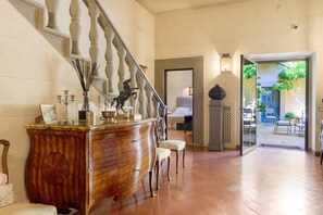 Eine prächtige Treppe führt zu einer Empore mit einem Holzschrank und Sesseln.