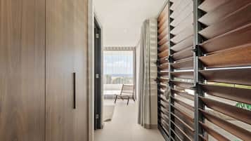 Een gang met een houten garderobe, een stoel en uitzicht op het buiten.
