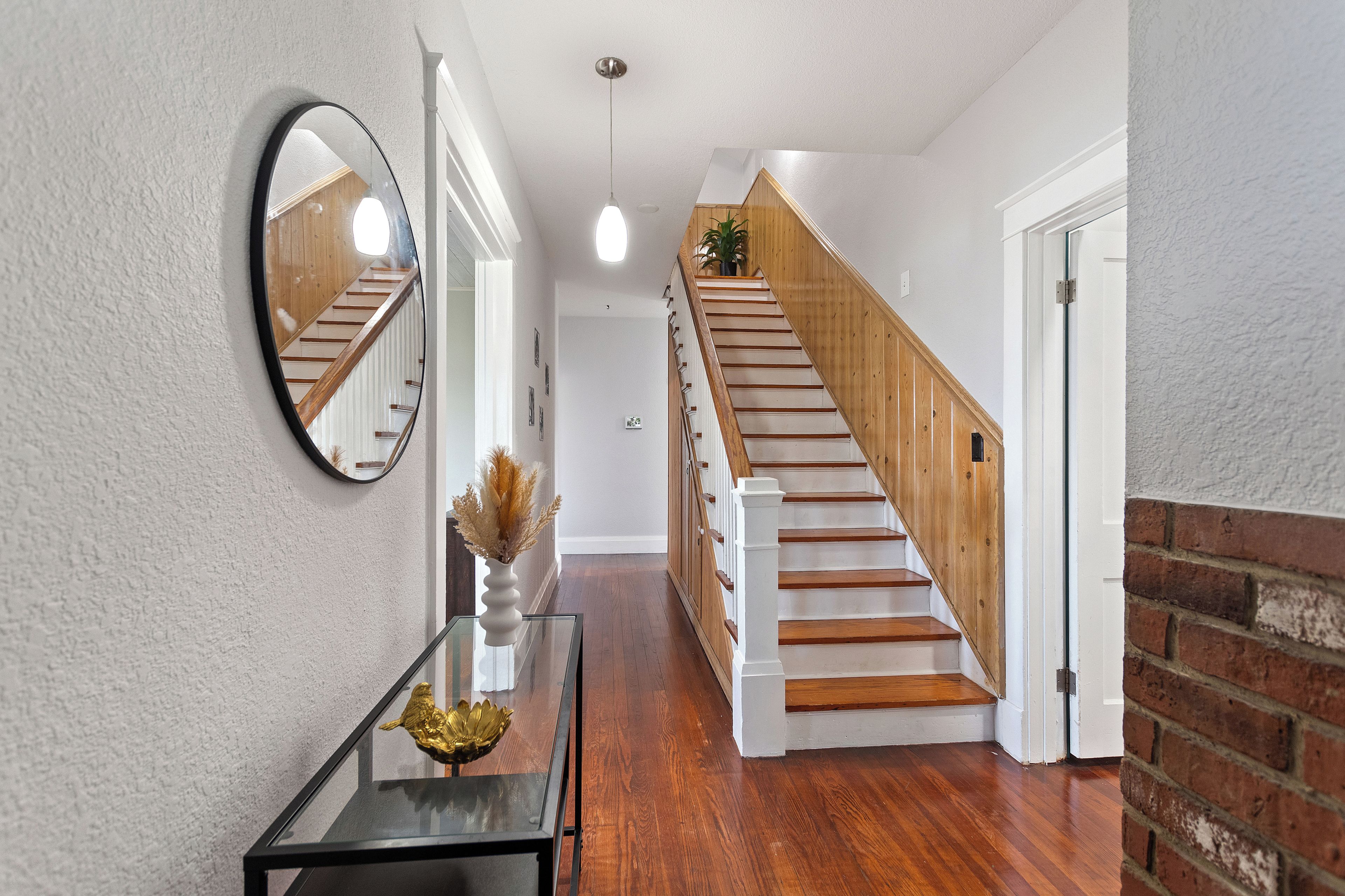 A staircase with wooden steps and white railings, leading to an upper floor.