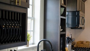 Een keuken met een zwarte kraan, een magnetron en een fornuis.