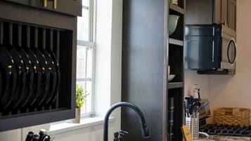 A kitchen with a black faucet, a microwave, and a stove.
