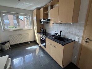 Eine moderne Küche mit Fenster, Heizkörper und Spüle.