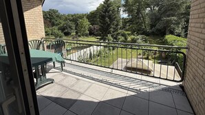 A balcony with a view of a garden and trees. - Garden Retreat by Loftigo - Balcony & Natural Serenity (Selfkant)