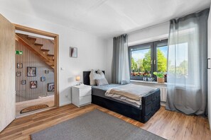 Una camera da letto con un letto, un comodino e una finestra con tende.