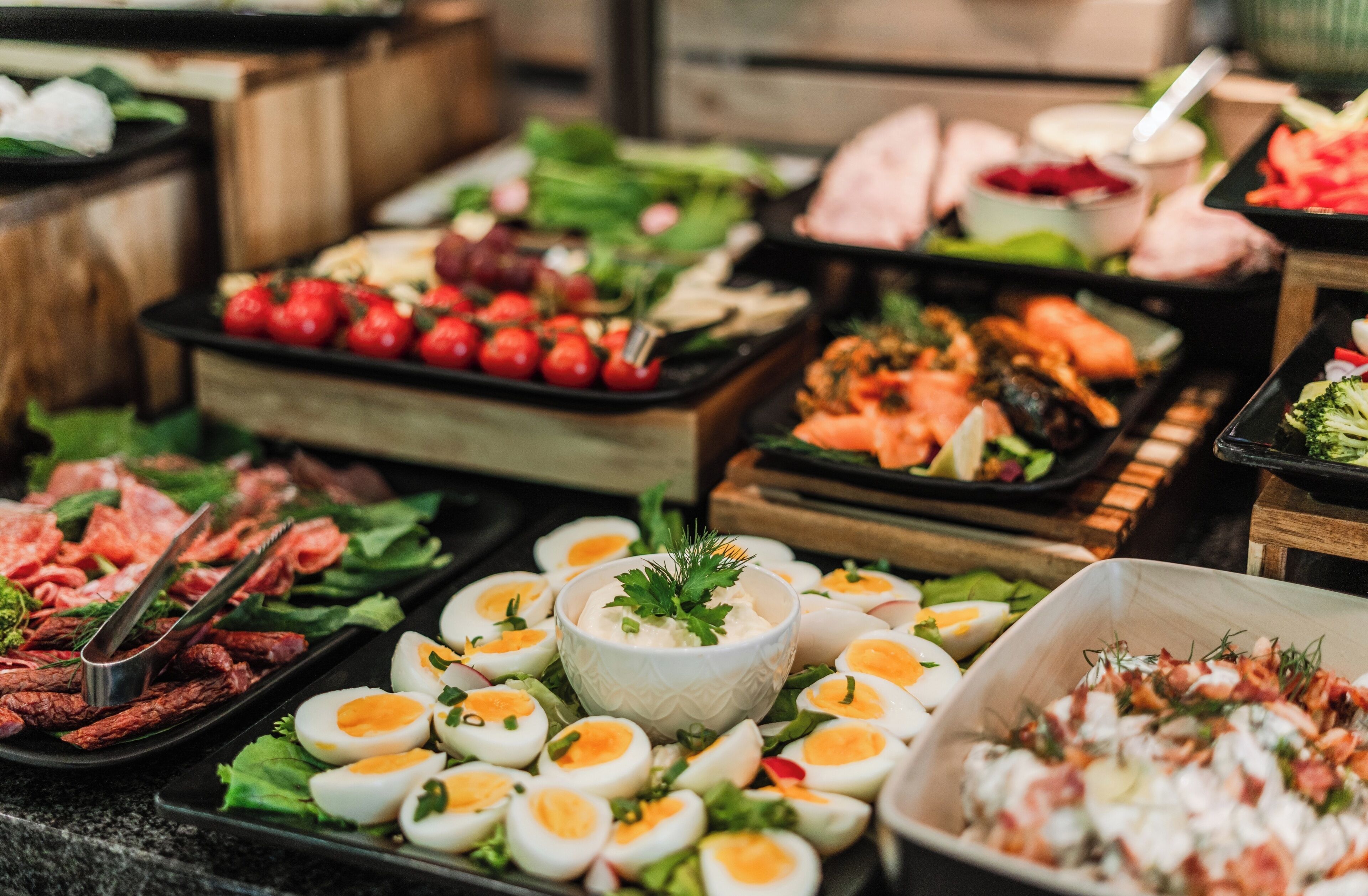Un buffet proposant une variété de plats, notamment des œufs, de la viande et des légumes.