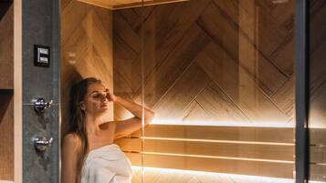 A sauna with a wooden interior, a bench, and a towel.