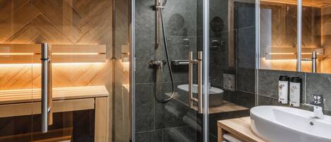 A modern bathroom with a glass-enclosed shower, a wooden vanity, and a large mirror.