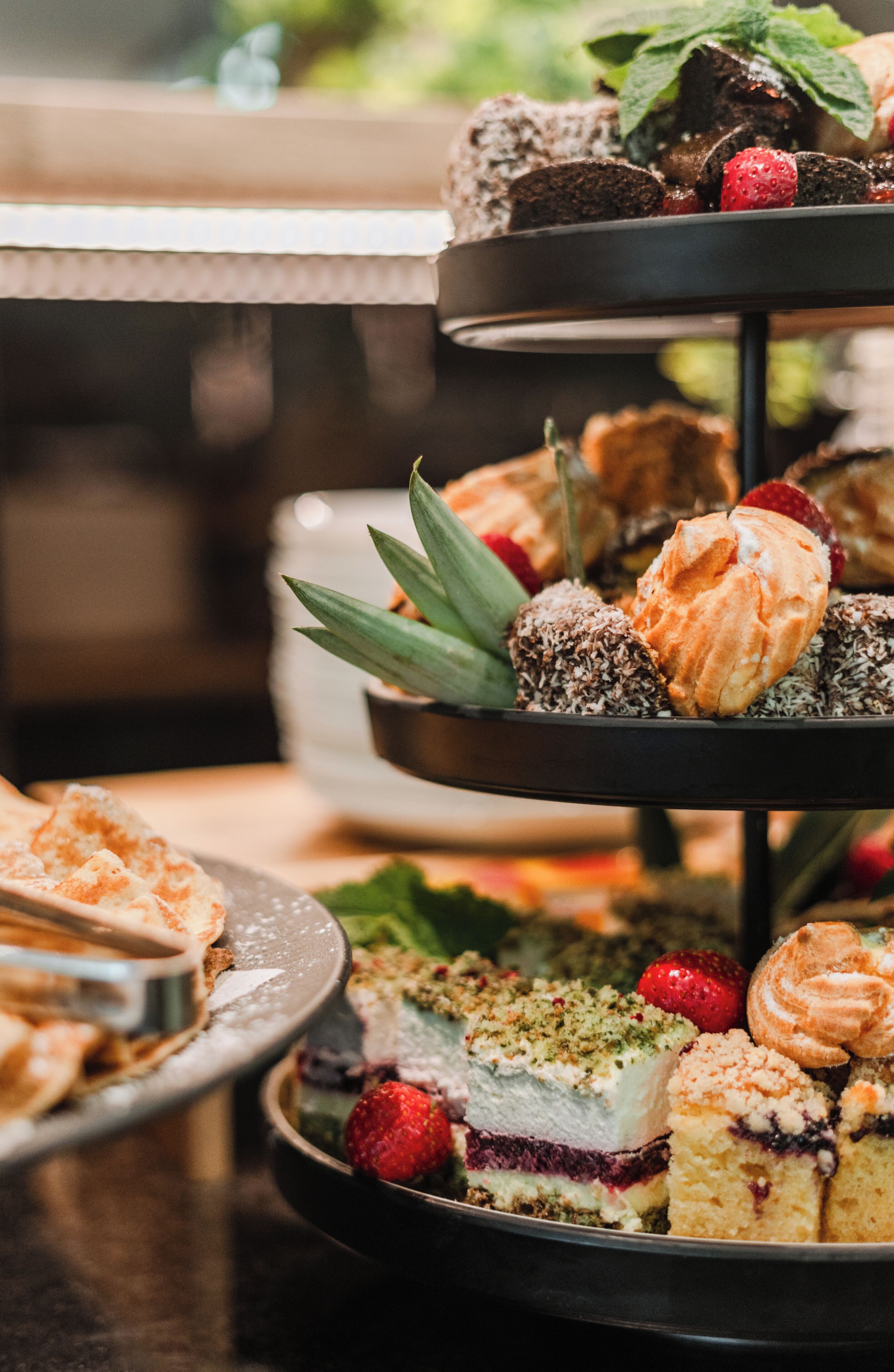 Un présentoir à plusieurs niveaux où sont exposés divers gâteaux et pâtisseries.