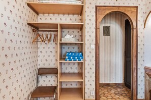 A room with a wooden wardrobe, a chair, and a door leading to another room. - Chez Daniel et Zdenka – Deborah Room (Villars-les-Dombes)
