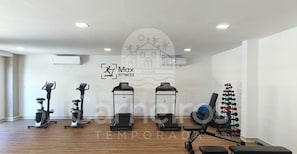 Ein Fitnessstudio mit Ergometer, Laufband und Gewichten.