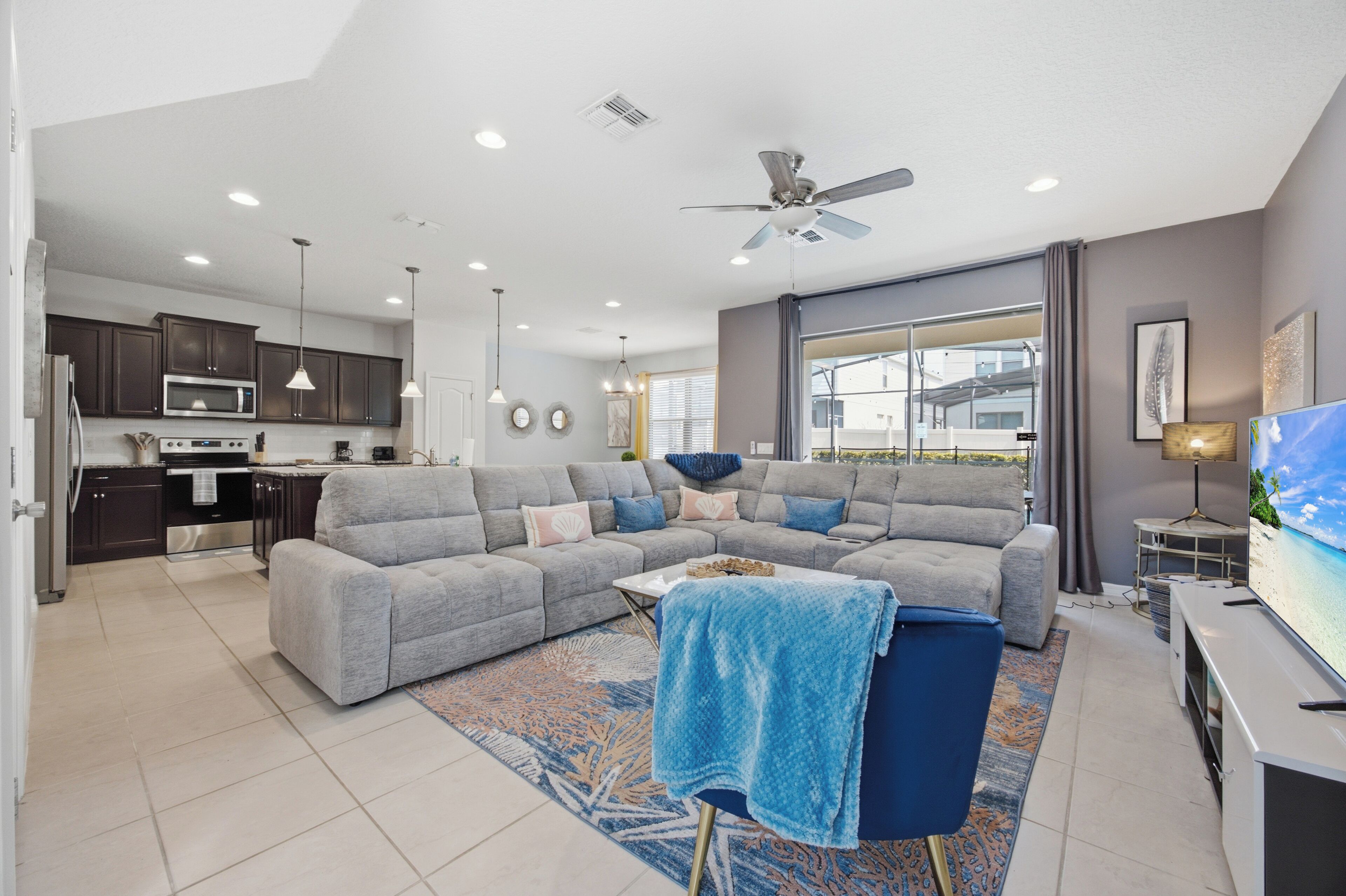 A modern living room with a grey sectional sofa, a coffee table, and a TV on a stand.