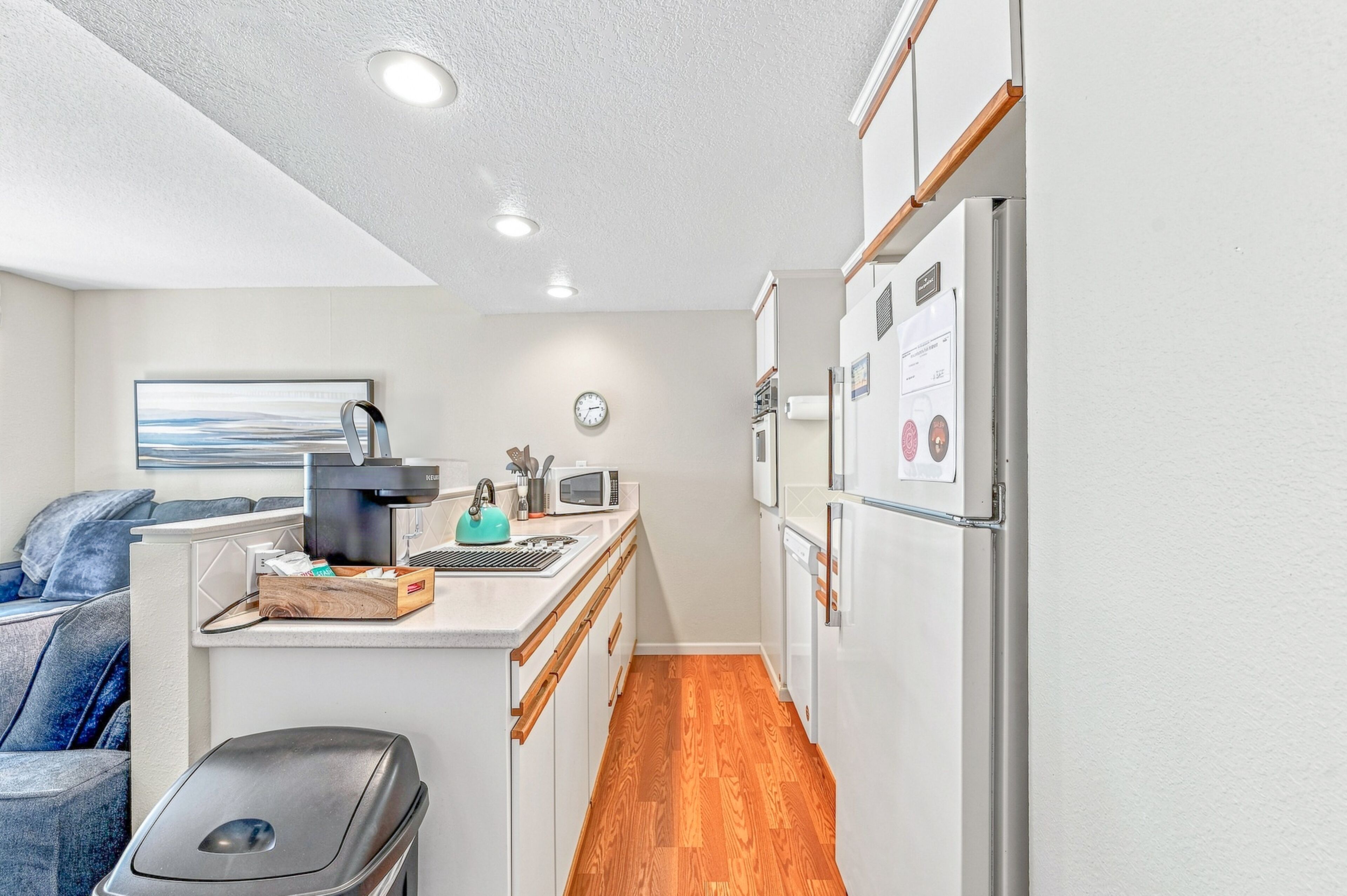 A compact kitchen with a coffee machine, microwave, and refrigerator.