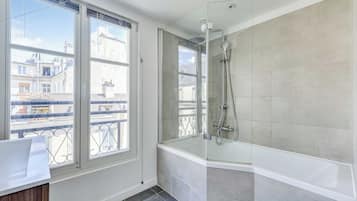 Appartement | Badkamer | Een bad, een haardroger, handdoeken, shampoo