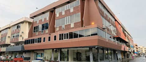 A multi-story building with a modern design, featuring large windows and a flat roof.