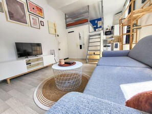 Ein modernes Wohnzimmer mit einer Couch, einem Fernseher und einem Couchtisch.