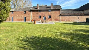 Un edificio in mattoni con un ampio prato antistante.