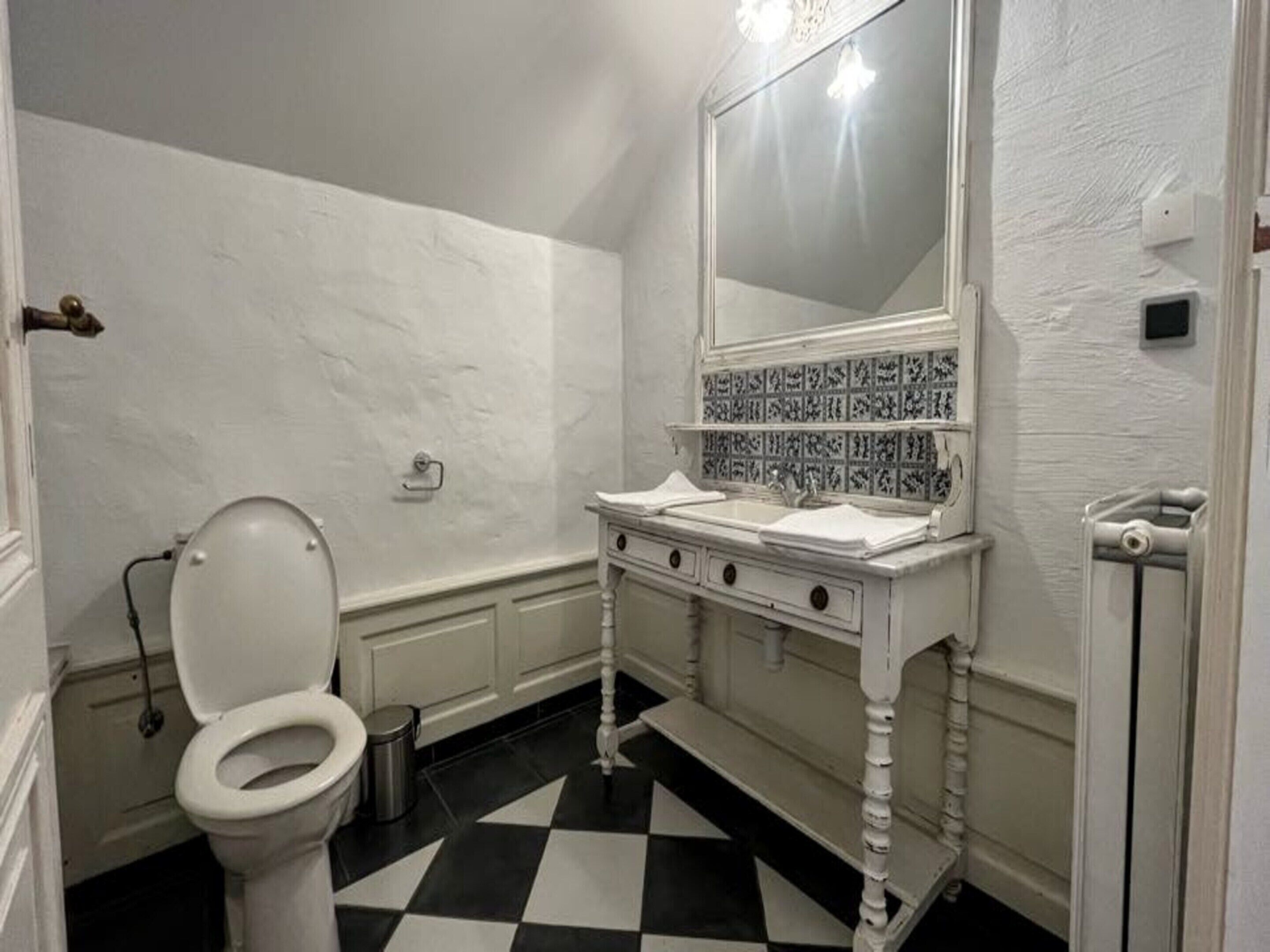 Un baño con inodoro, lavabo y espejo.
