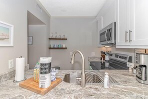 A modern kitchen with a stainless steel sink, a microwave, and a coffee maker. - Ocean Creek Resort: 7-min walk to beach (Myrtle Beach)