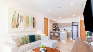 Ein modernes Wohnzimmer mit einer Couch, einem Couchtisch und einem Gemälde an der Wand.