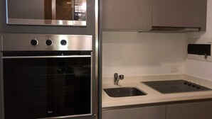 Een moderne keuken met een ingebouwde oven, een spoelbak en een magnetron.