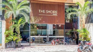 Een modern gebouw met een bord waarop staat 'THE SHORE AT46'.