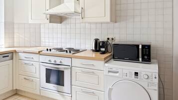 Una cocina moderna con estufa, horno, microondas y lavadora.