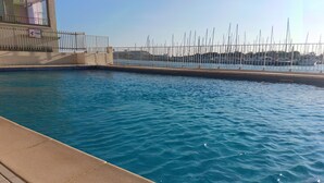 Une piscine avec vue sur un port de plaisance.