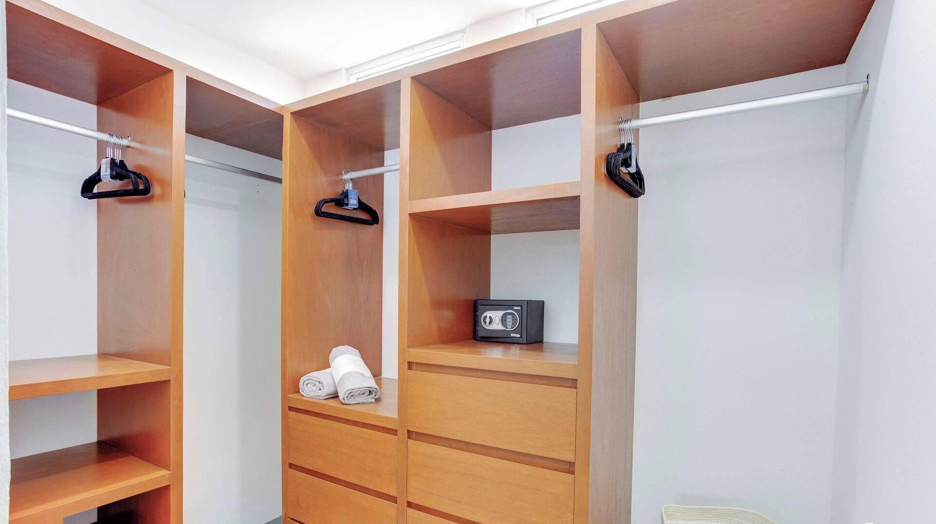 Ein begehbarer Kleiderschrank mit mehreren Regalen, einer Kleiderstange und einem kleinen Radio.