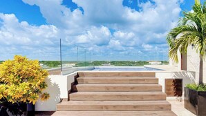 A rooftop terrace with a pool, wooden steps, and a view of the landscape. - Ocean-view retreat w/ pool & parking (Playa del Carmen)