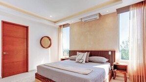 A bedroom with a large bed, a wooden headboard, a wall-mounted air conditioning unit, and a view of the outdoors through a window. - Ocean-view retreat w/ pool & parking (Playa del Carmen)