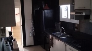 A kitchen with a refrigerator, stove, sink, and cabinets. - Cozy Villa in Downtown Agadir (Agadir)