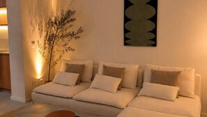 A modern living room with a sofa set, a coffee table, and a wall-mounted artwork. - Maison Bruxelles (Schaerbeek)