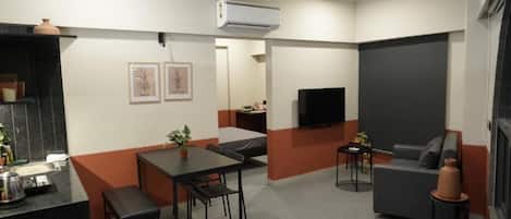 Una sala moderna con un sofá, una mesa de comedor y un televisor.