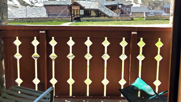 A balcony with a view of snow-capped mountains, a wooden fence, and two chairs. - Thémis 112 - The Alpine Cocoon (La Plagne Tarentaise)