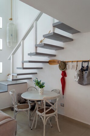 A modern interior with a staircase, dining area, and wall-mounted items. - Plaza Paraiso retreat w/ rooftop pool (Playa del Carmen)