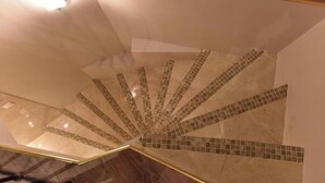 A spiral staircase with a mirrored wall and a tiled floor. - Deluxe Loft at Le Moulin Vert (Paris)
