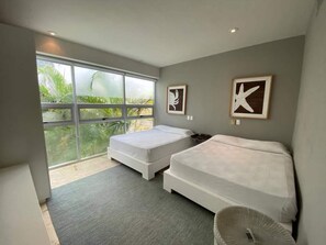 A modern bedroom with two beds, large windows, and artwork on the walls. - Terrace retreat w/ pool, gym & balcony (Playa del Carmen)