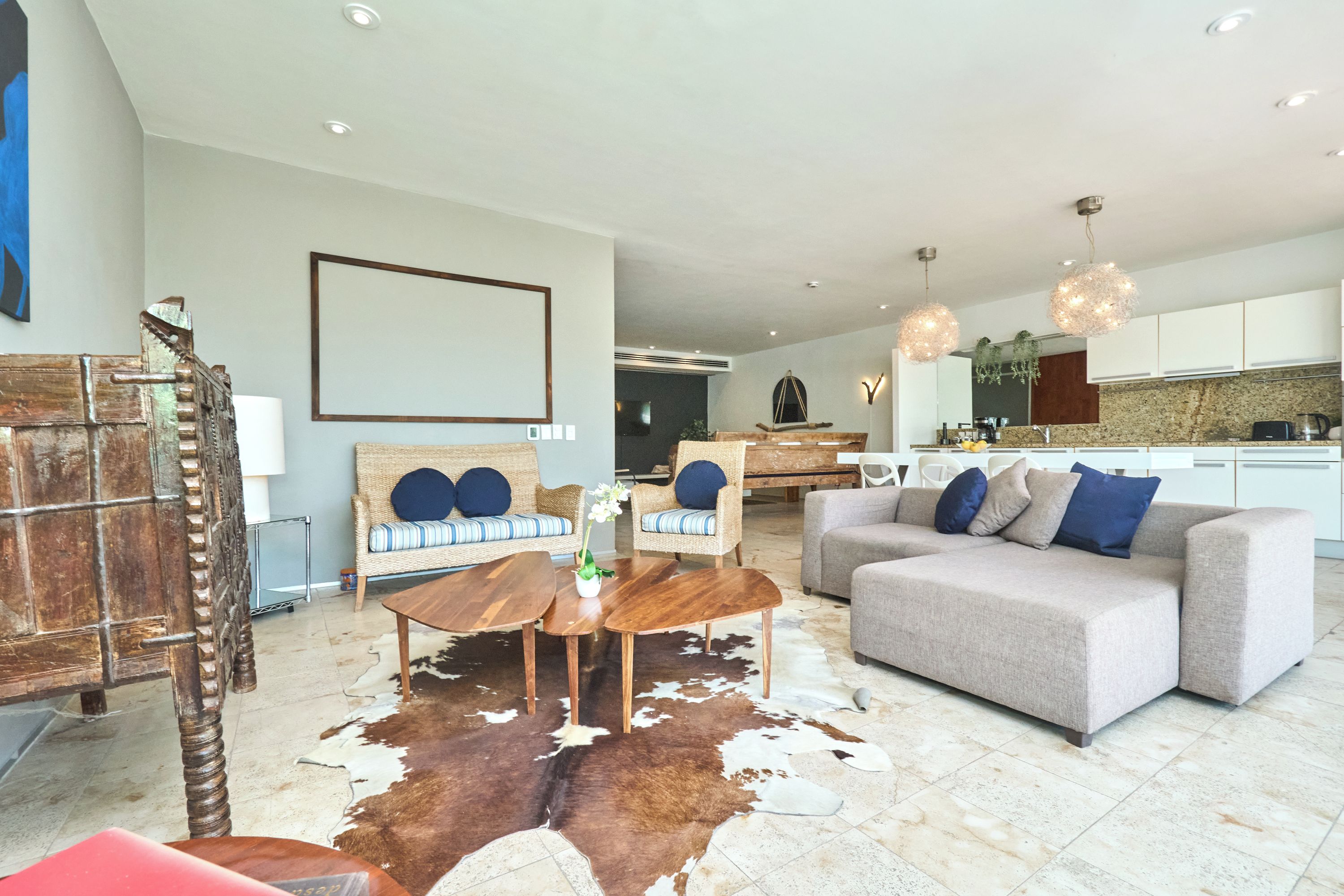 A modern living room with a sofa, coffee table, and a cowhide rug.