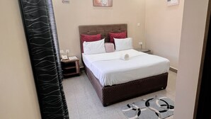 A hotel room with a bed, nightstands, a ceiling light fixture, and a wall-mounted artwork.