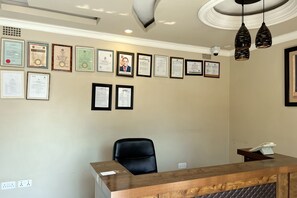 A reception desk with framed certificates on the wall.