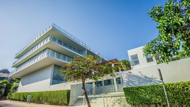 A modern building with a flat roof, large windows, and a balcony on the upper floor. - Beachside escape w/ pool & balcony (Playa del Carmen)