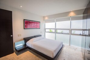Een moderne slaapkamer met een bed, een groot raam en een wanddecoratie.