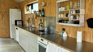 Et moderne køkken med træskabe, rustfrie hvidevarer og en bordplade med forskellige køkkenredskaber.