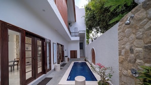 Un edificio moderno con piscina, una escalera y una planta en maceta.