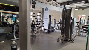 A gym with various exercise equipment, a mirrored wall, and a banner with motivational words. - Room-luxurious 2-bedroom Apartment in Ja (Johannesburg)