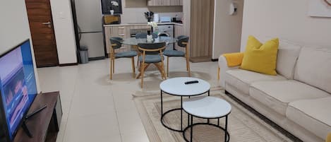 Una sala de estar moderna con sofá, mesa de centro y mueble para televisor.