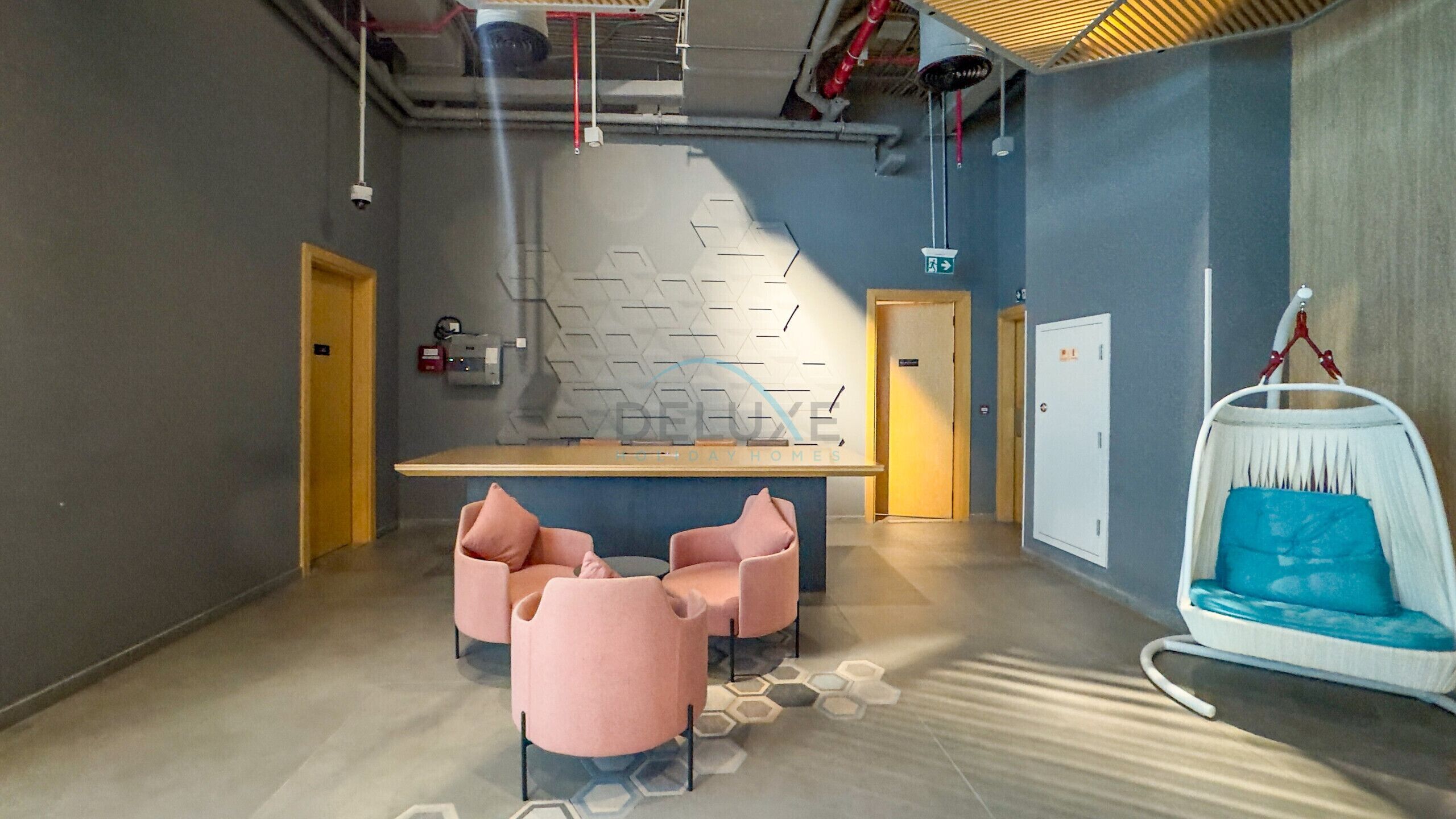 Un interno moderno con una zona salotto centrale, un design murale originale e una poltrona sospesa.