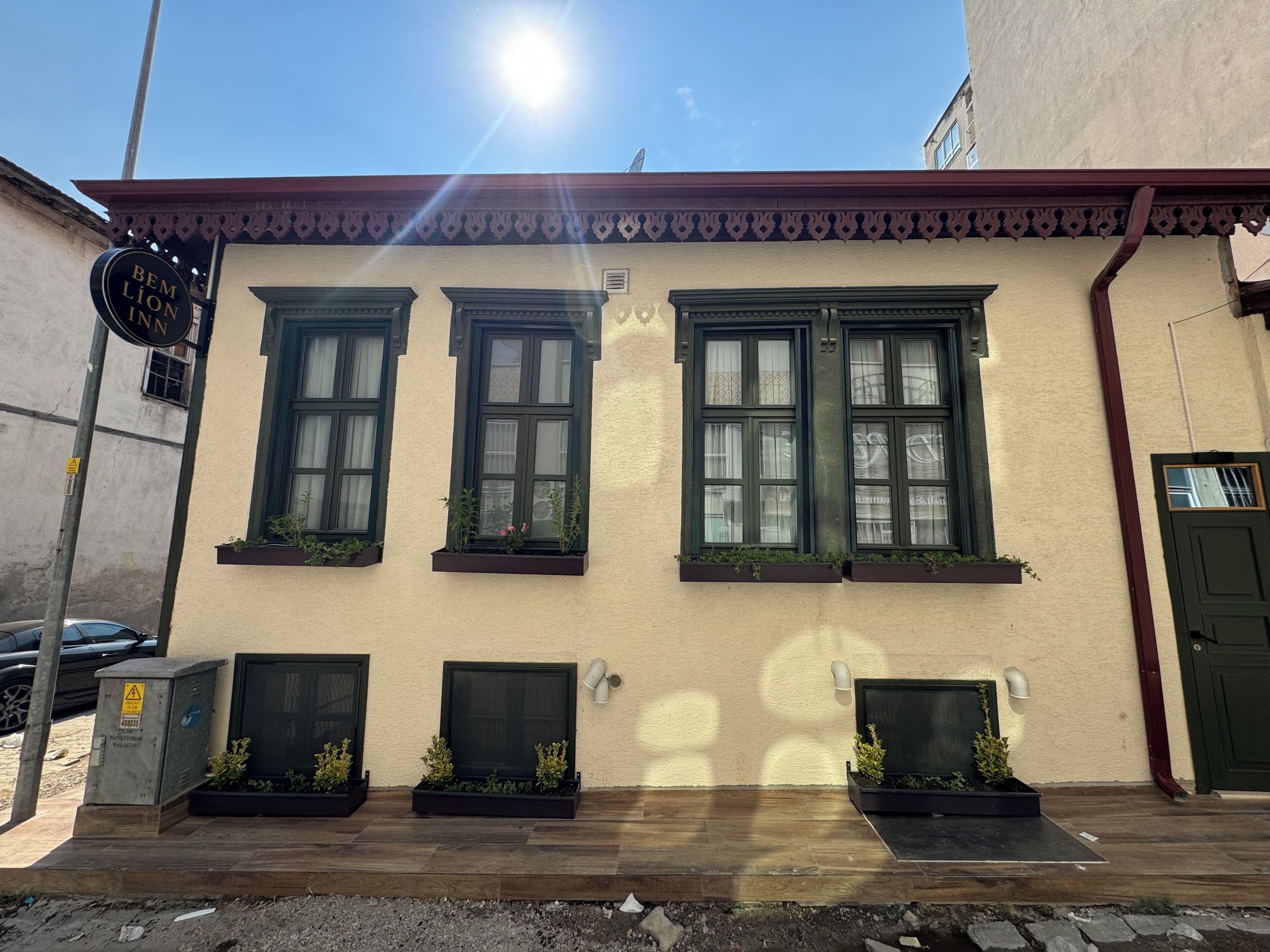 Un edificio con tres ventanas, una puerta y un letrero.